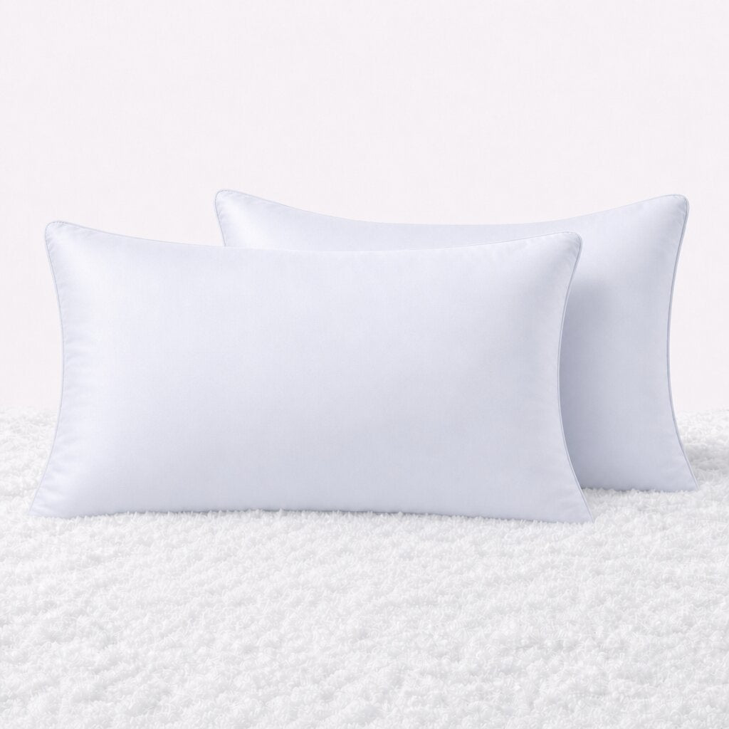 Two pillows in white pillowcases arranged upright on a white textured surface.