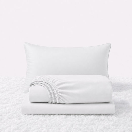 White sheet set displayed with one pillow behind a folded fitted sheet and flat sheet on a white textured surface.