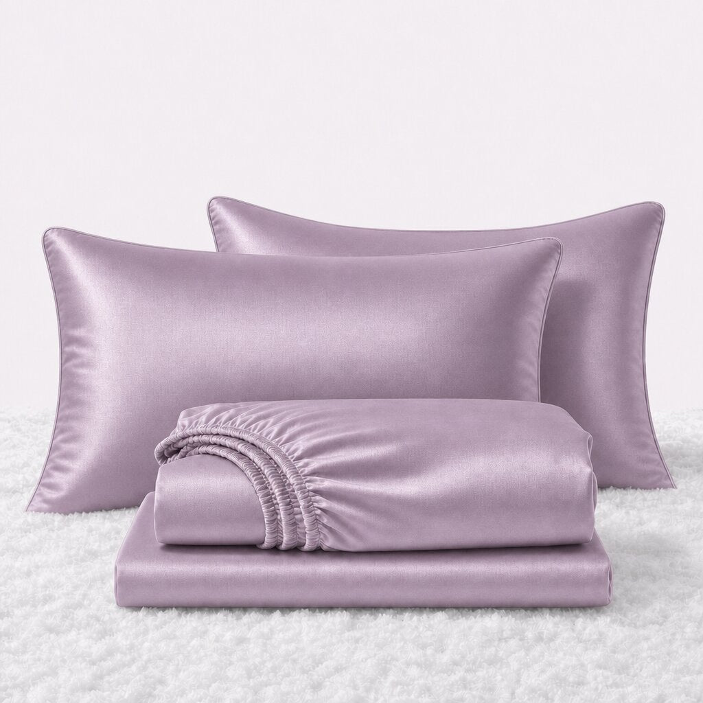 Folded shiny lavender satin sheets in front of two matching pillows on a white textured surface.