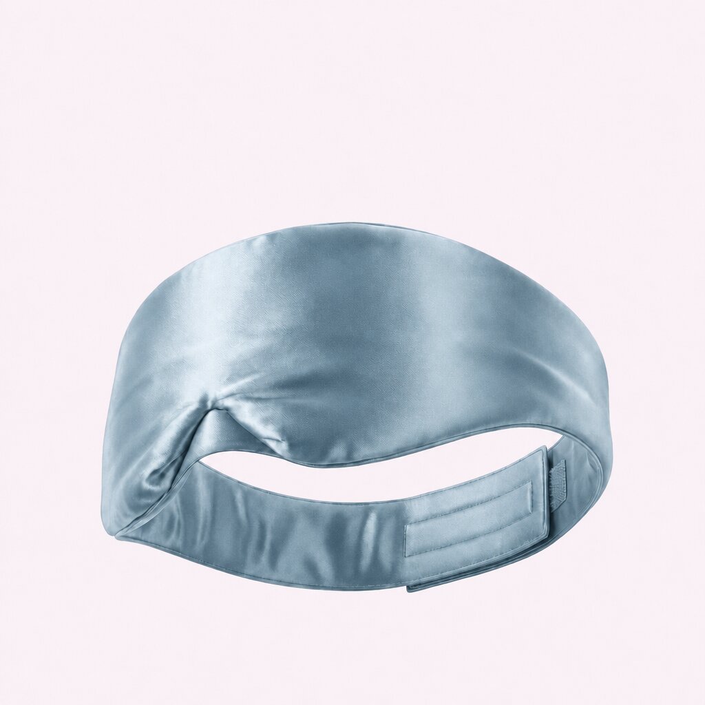Pale blue wide sleep mask viewed from behind, showing its adjustable fastening strap on a pale background.