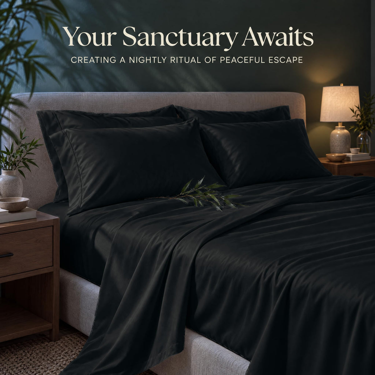 Black sheets and matching pillows on a bed beside a lamp, beneath the heading "Your Sanctuary Awaits".
