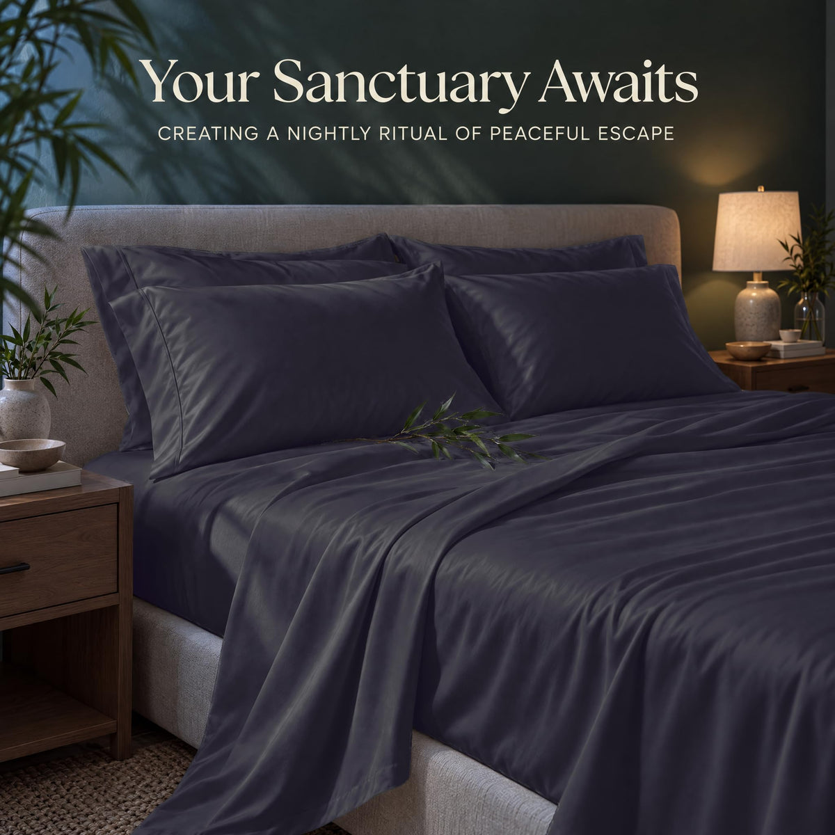 Slate blue sheets and matching pillows on a bed beside a lamp, beneath the heading "Your Sanctuary Awaits".
