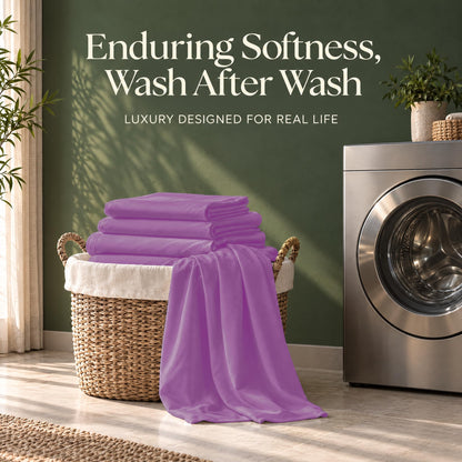 Folded purple sheets on a wicker basket beside a washing machine, with the words "Enduring Softness, Wash After Wash".