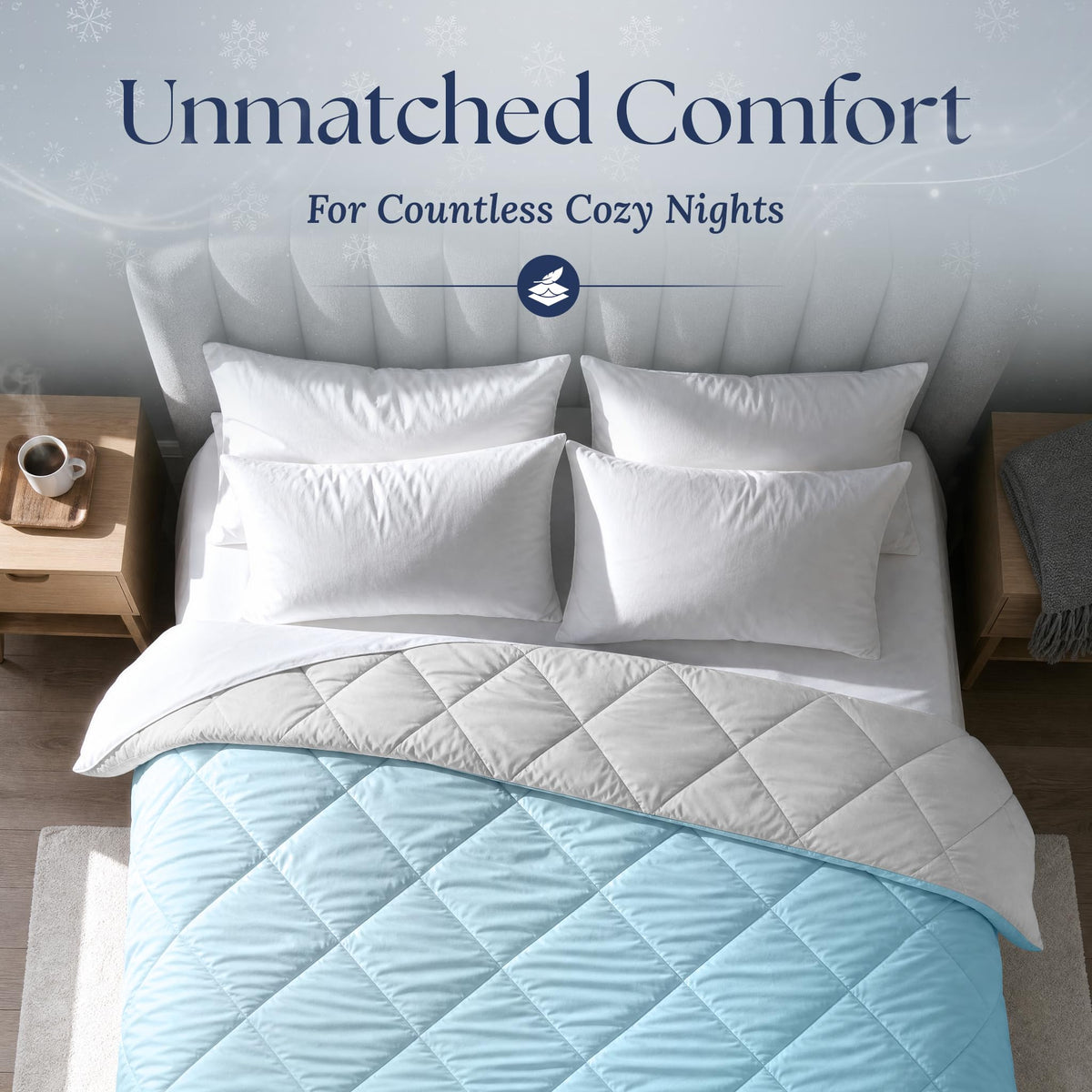 Overhead view of a light blue diamond quilted comforter folded back to show its light gray reverse, with four white pillows.