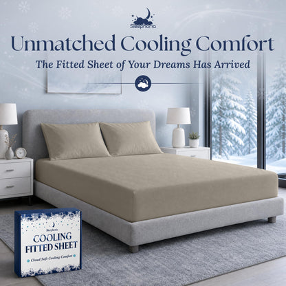 Beige fitted sheet pulled over a mattress with two matching pillows on a gray bed, beside Sleephoria packaging.