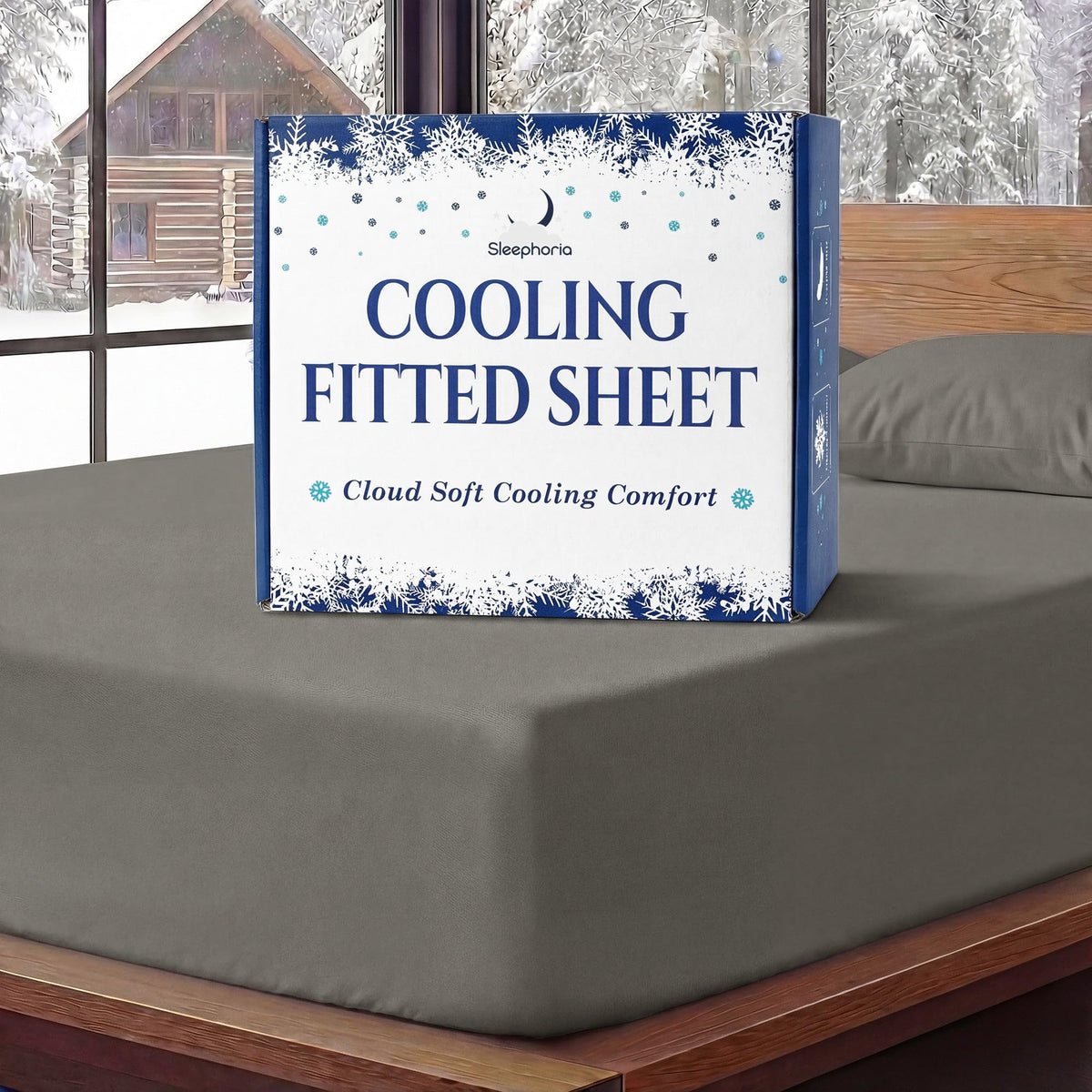 Sleephoria Cooling Fitted Sheet box standing on a warm gray fitted sheet, with matching pillows and snowy trees outside.