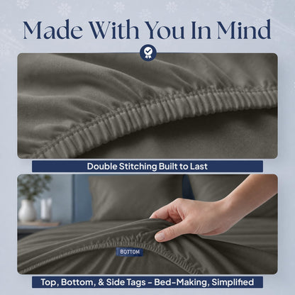 Warm gray fitted sheet details showing double stitching along the elastic edge and a hand holding the "BOTTOM" orientation tag.