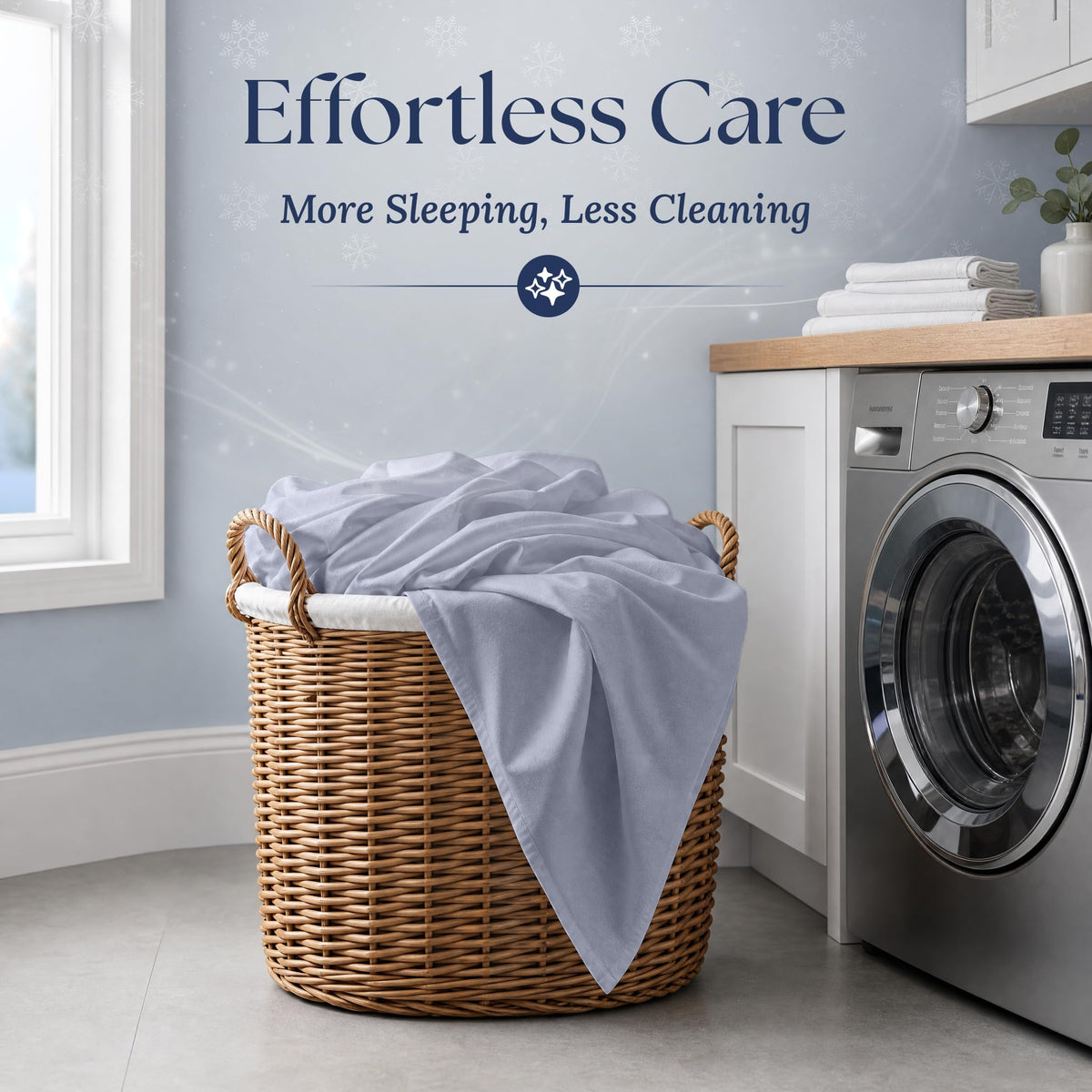 Pale blue gray fitted sheet draped over a wicker laundry basket beside a washing machine. Graphic reads "Effortless Care".