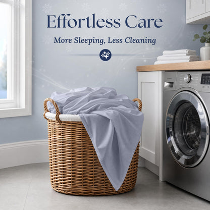 Pale blue gray fitted sheet draped over a wicker laundry basket beside a washing machine. Graphic reads "Effortless Care".