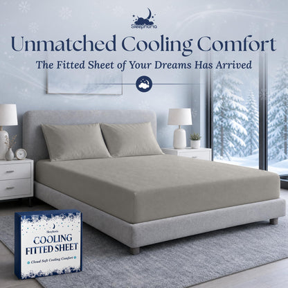 Light gray fitted sheet pulled over a mattress with two matching pillows on a gray bed, beside Sleephoria packaging.