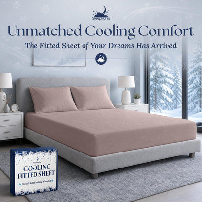 Blush pink fitted sheet pulled over a mattress with two matching pillows on a gray bed, beside Sleephoria packaging.
