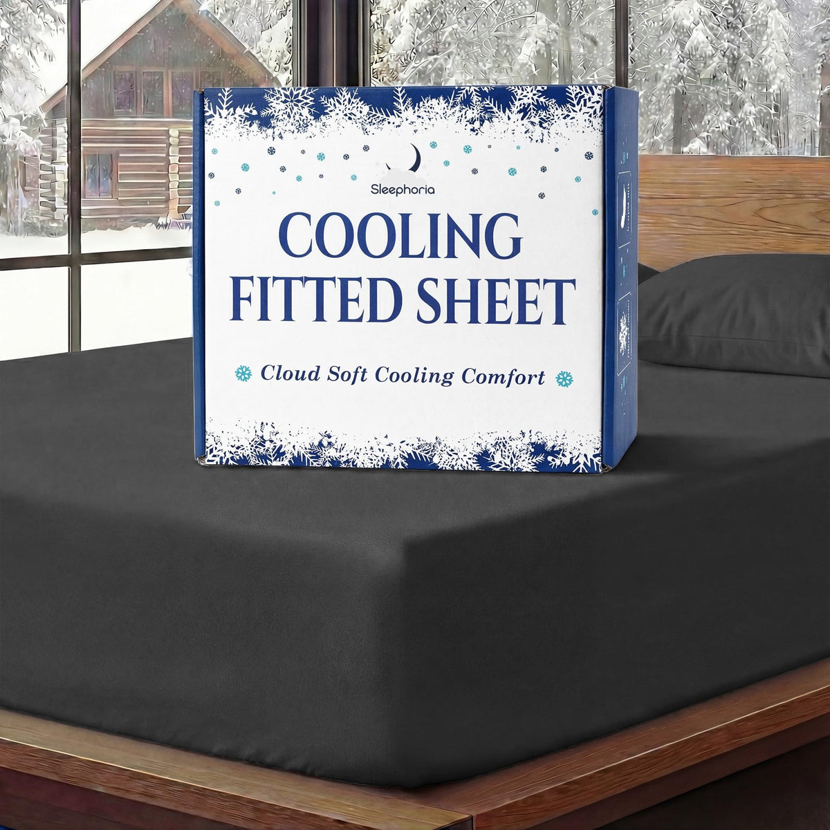 Sleephoria Cooling Fitted Sheet box standing on a black fitted sheet, with matching pillows and snowy trees outside.