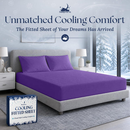 Purple fitted sheet pulled over a mattress with two matching pillows on a gray bed, beside Sleephoria packaging.