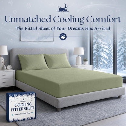 Sage green fitted sheet pulled over a mattress with two matching pillows on a gray bed, beside Sleephoria packaging.
