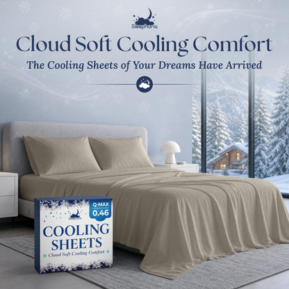 Beige sheets and two matching pillows on a gray bed beside Sleephoria Cooling Sheets packaging, with snowy trees outside.