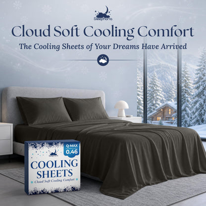 Charcoal gray sheets and two matching pillows on a gray bed beside Sleephoria Cooling Sheets packaging, with snowy trees outside.