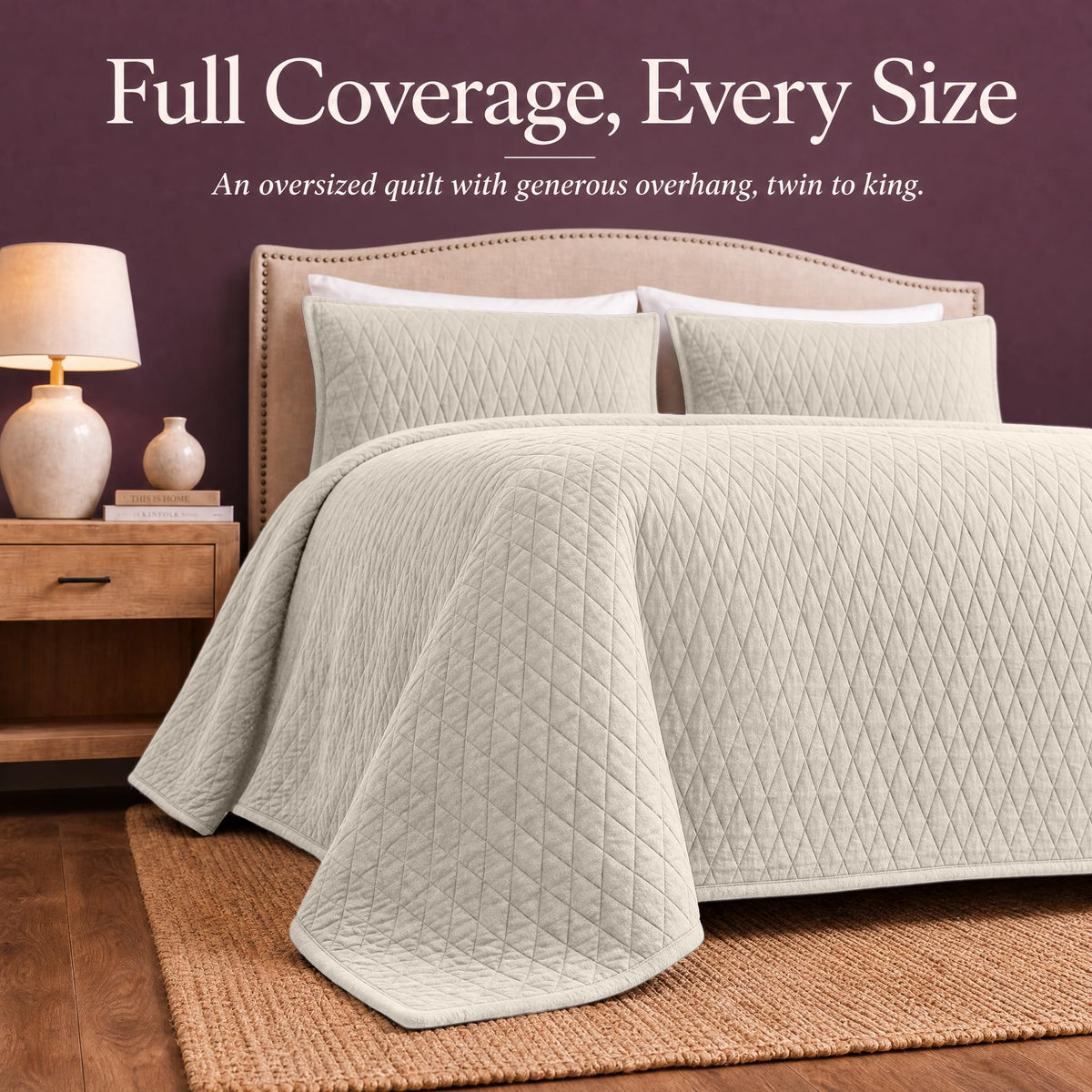 Ivory diamond quilt draped over both sides and the foot of a bed with matching shams beneath "Full Coverage, Every Size".