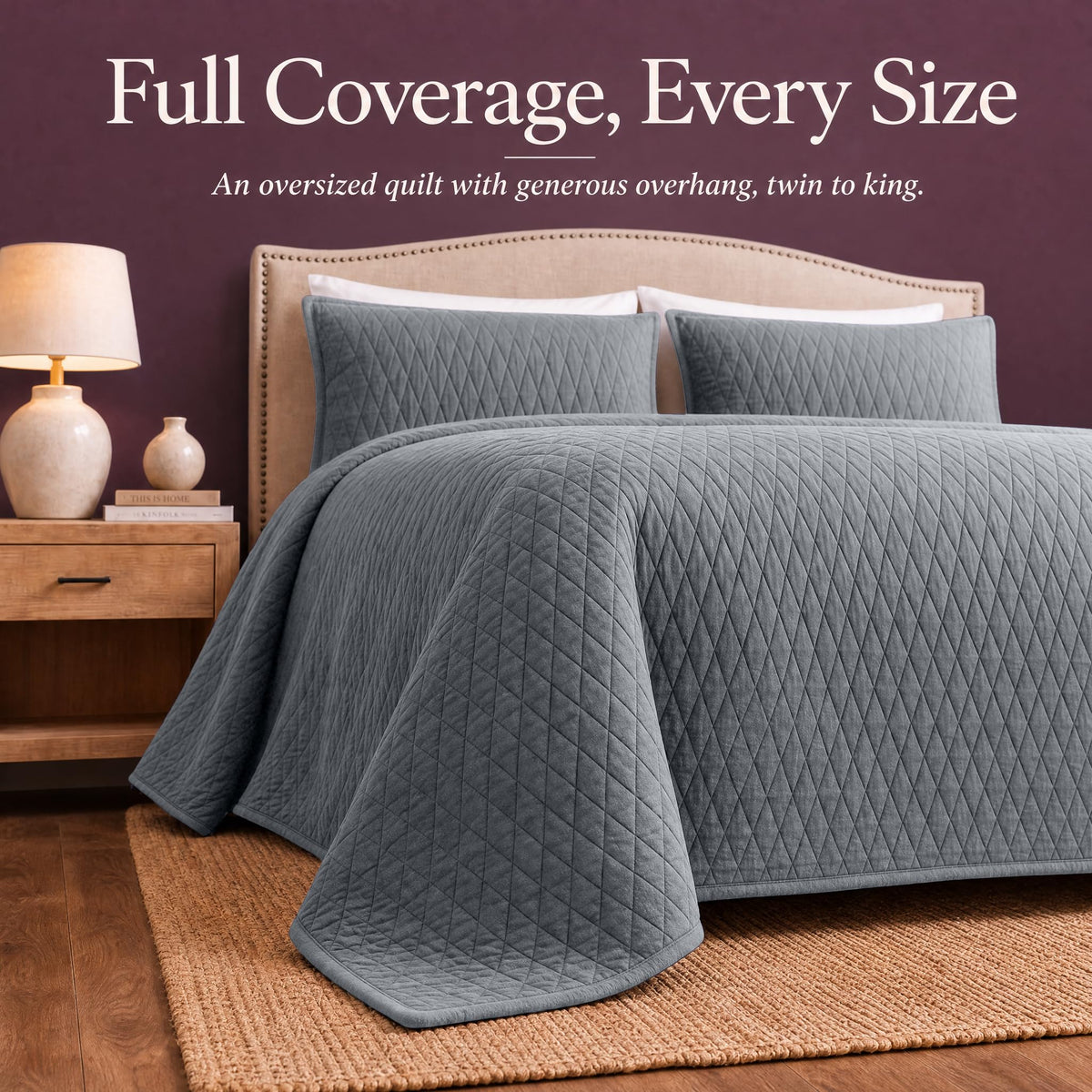 Gray diamond quilt draped over both sides and the foot of a bed with matching shams beneath "Full Coverage, Every Size".