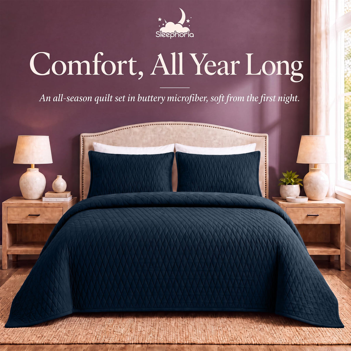Navy blue diamond quilt and matching shams on a bed between wooden nightstands beneath "Comfort, All Year Long".