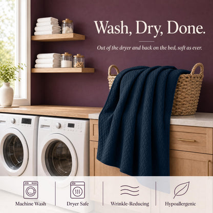 Navy blue quilt draped over a wicker basket above laundry machines beneath "Wash, Dry, Done".
