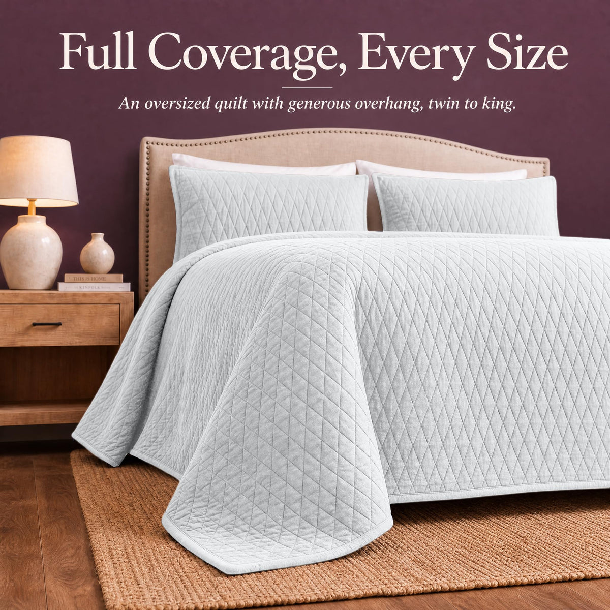 White diamond quilt draped over both sides and the foot of a bed with matching shams beneath "Full Coverage, Every Size".