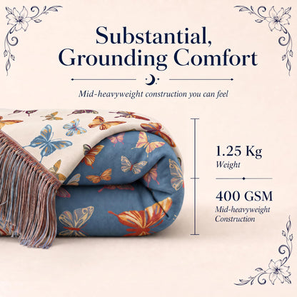 Folded blue butterfly patterned fringed throw in a "Substantial, Grounding Comfort" graphic labeled 1.25 kg and 400 GSM.