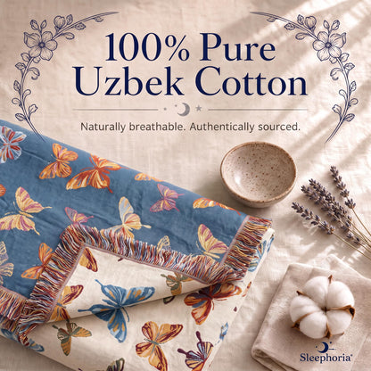 Blue butterfly patterned reversible fringed throw on cream fabric beside a bowl, cotton boll and lavender, with a printed 100% Pure Uzbek Cotton heading.